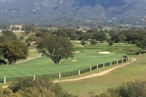 Equestrian ranch with green pastures and mountains